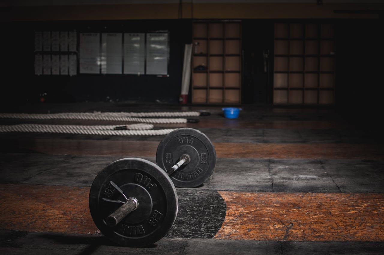 Offering A lone barbell rests in an empty, dimly lit gym, emphasizing strength and solitude.