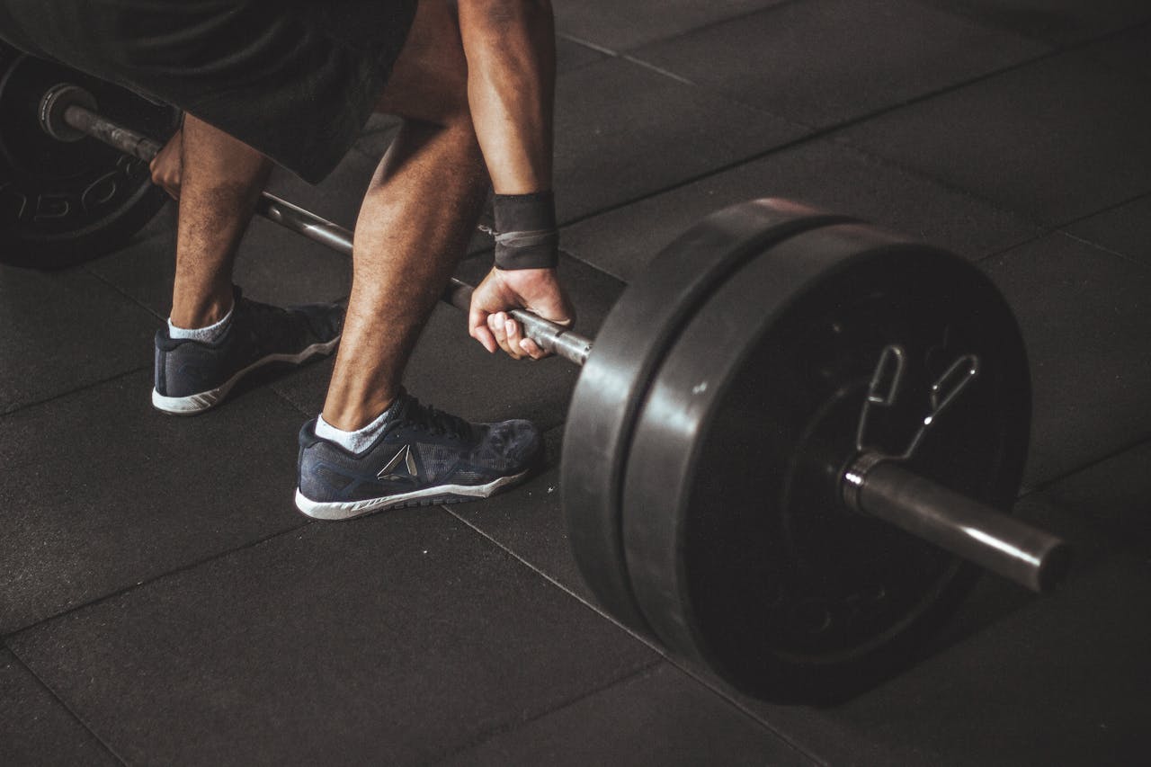 Offering A man lifting a heavy barbell during a gym workout, showcasing strength and fitness.